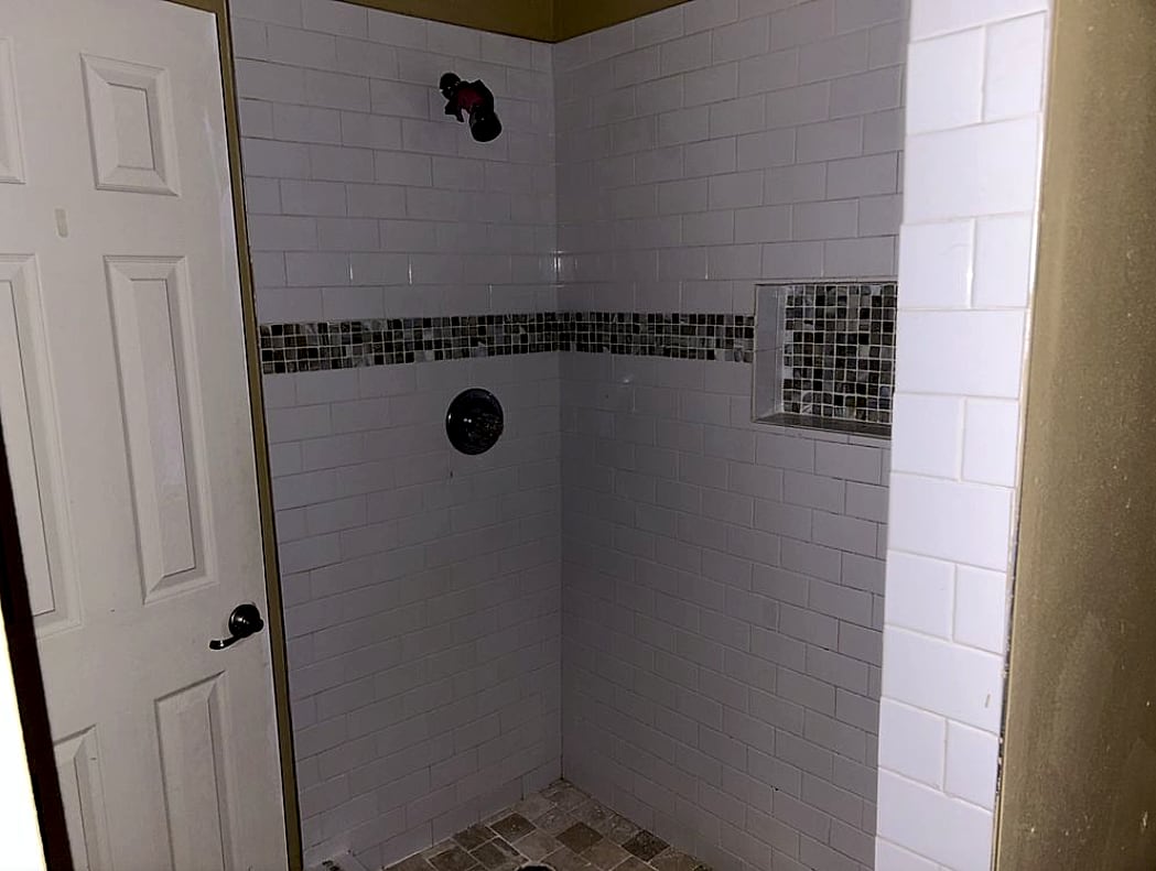 Tiled shower with mosaic accent band, built by Apex in Columbia, MS